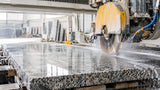 Professional bridge saw cutting a granite slab with a diamond blade