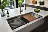 Kitchen sink accessories including sink grid, drying rack, cutting board and colander in a modern kitchen